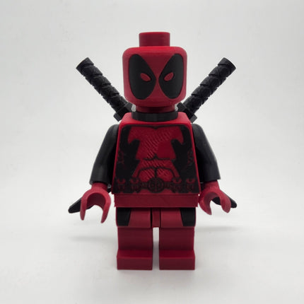 Oversized Deadpool inspired red and black brick-style collectible with twin swords