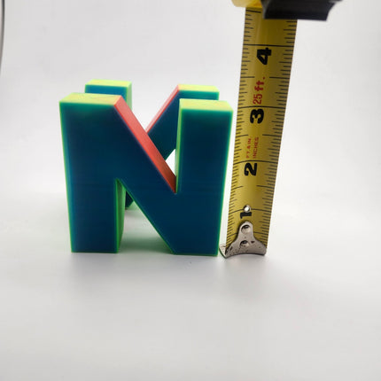 N64 inspired retro gaming logo shown beside tape measure at about three inches tall