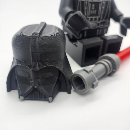 Close-up removable black Vader-inspired helmet and red saber accessory